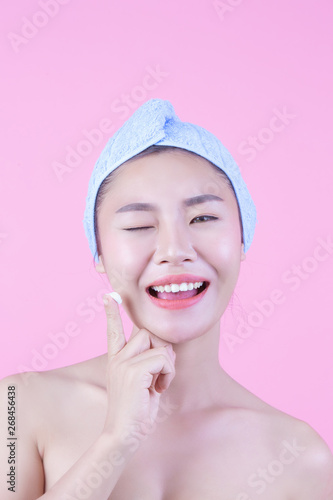 Beautiful woman asia is washing her face on pink background.