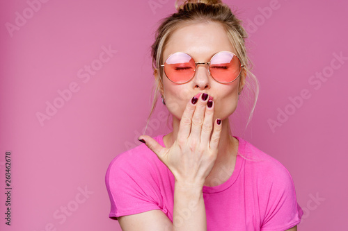 Image of blonde woman in pink t-shirt blowing kiss