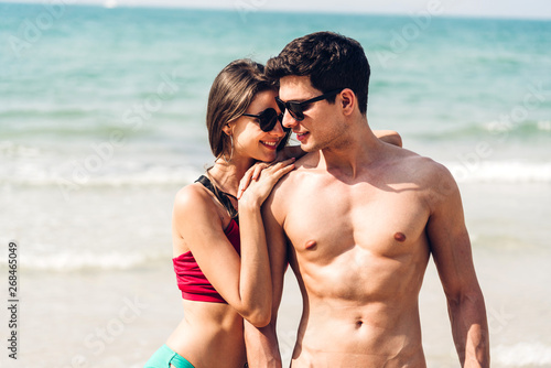 Romantic lovers young couple holding hands walking relaxing together on the tropical beach.Summer vacations