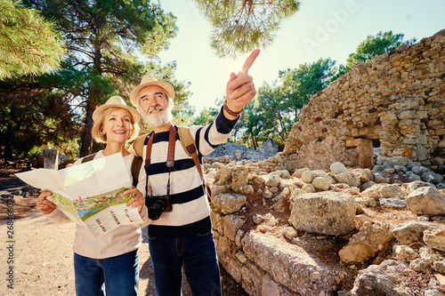 Family, age, tourism and travel concept. Happy senior couple with map at ancient sightseeing.