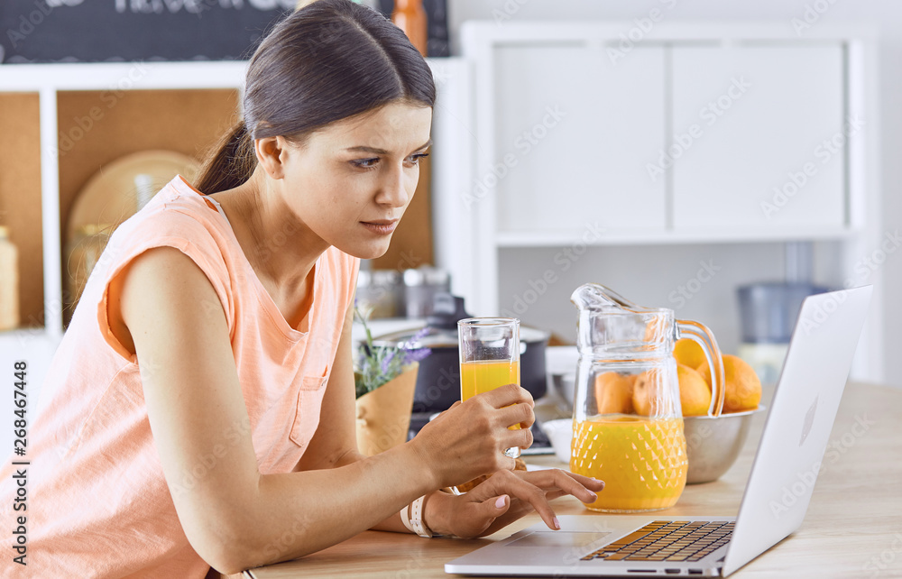 Smiling pretty woman looking at mobile phone and holding glass Smiling pretty woman looking at mobile phone and holding glass