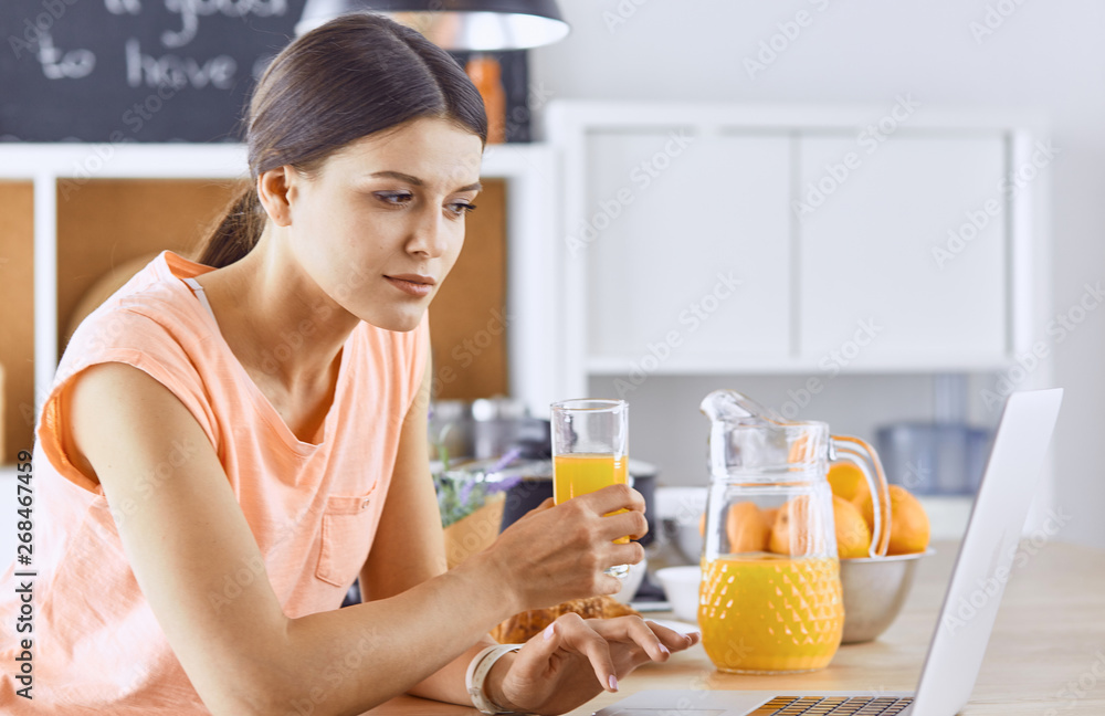 Smiling pretty woman looking at mobile phone and holding glass Smiling pretty woman looking at mobile phone and holding glass