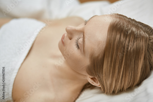 Beautiful young woman in cosmetic salon close up