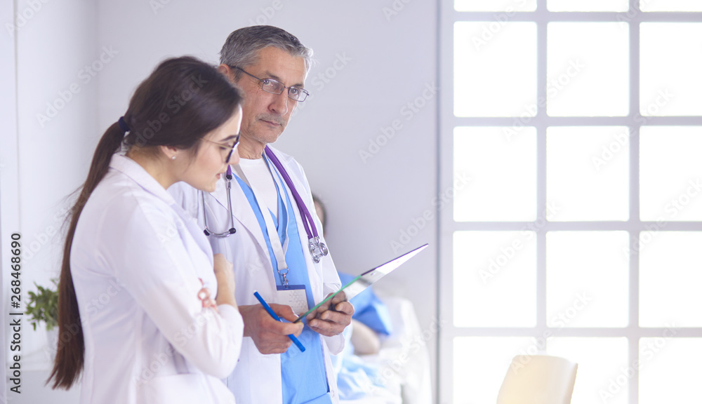 Doctor checking heart beat of patient in bed with stethoscope Doctor checking heart beat of patient in bed with stethoscope