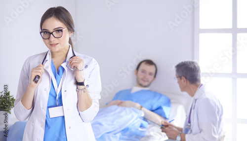 Doctor checking heart beat of patient in bed with stethoscope