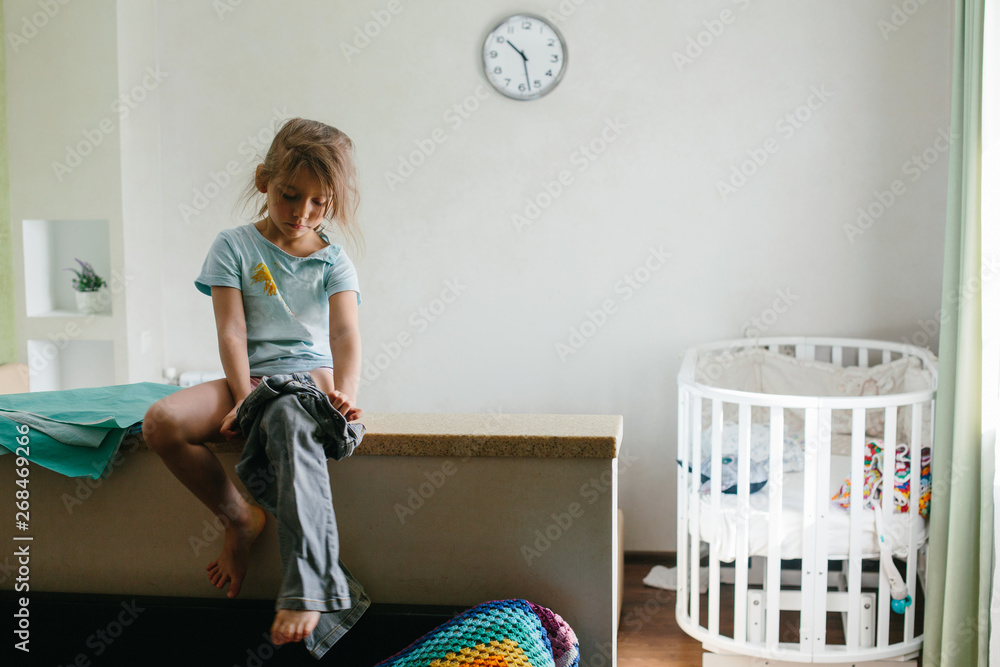 Little girl kid getting dressed by herself, going to kindergarten in