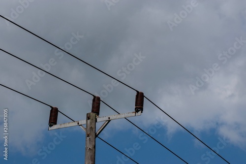 Obraz na płótnie Power cables seen against a blue sky with white clouds w salonie