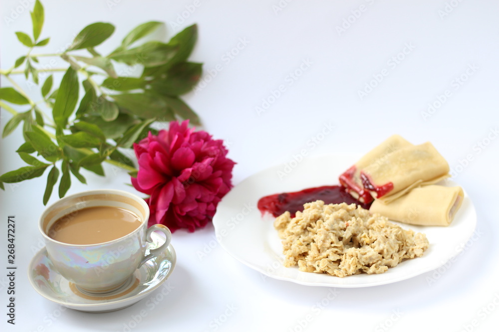 breakfast of oatmeal and pancakes with berries and a cup of coffee and next to a peony flower breakfast of oatmeal and pancakes with berries and a cup of coffee and next to a peony flower