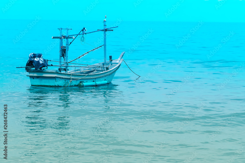 Fishing boat near shore in blue sea and blue sky meet. Thailand holiday summer vacation concept idea.