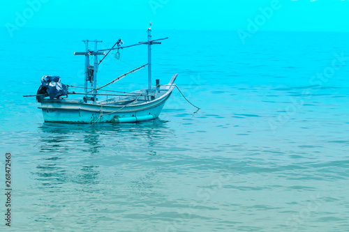 Fishing boat near shore in blue sea and blue sky meet. Thailand holiday summer vacation concept idea.