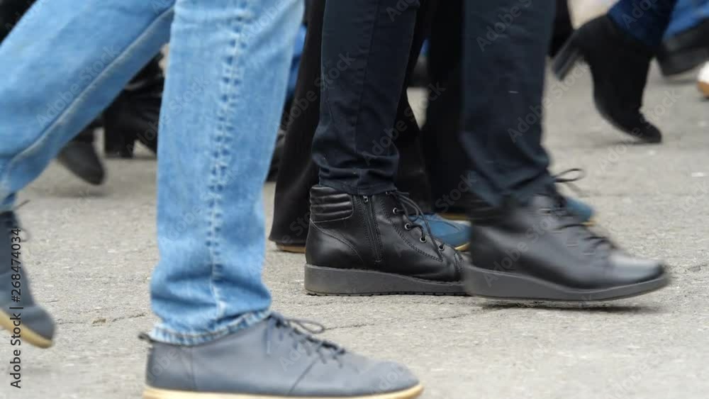 Feet walking past on pavement, go to one party, low angle showing the different types of footwear. Slow motion. Feet walking past on pavement, go to one party, low angle showing the different types of footwear. Slow motion.
