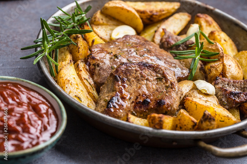 Beef grilled steaks with barbecue sauce roasted potatoes and rosemary