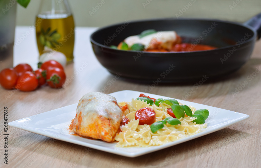 Farfalle pasta in tomato sauce with chicken, basil in plate