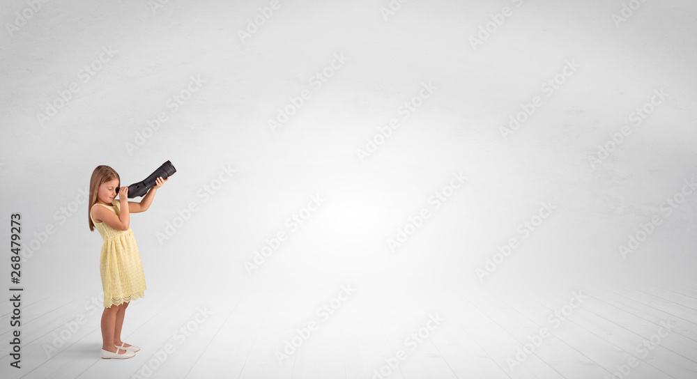 Cute little girl looking through spyglass to an empty space
Cute little girl looking through spyglass to an empty space