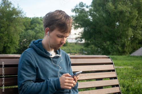 Young Teenager Man With Smartphone in City Park