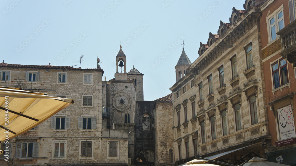 Split, Croatia - 07 22 2015 - Narodni trg, view of the street with city clock and stone houses in old town, beautiful architecture, sunny day, Dalmatia