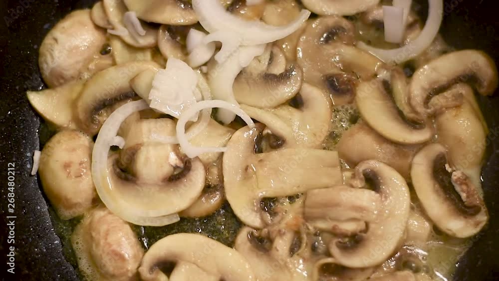 Mushrooms, fried in a pan in heated butter with onions and pepper. Mushrooms in the process of stewing and frying in a pan in butter Mushrooms, fried in a pan in heated butter with onions and pepper. Mushrooms in the process of stewing and frying in a pan in butter