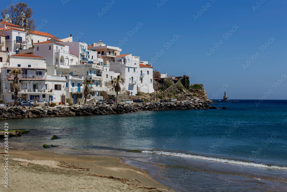 View of the town lighthouse, houses and the sea (Greece, island Andros, Cyclades)