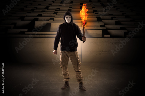 Ugly, aberrant man coming out from the labyrinth with burning flambeau on his hand
 photo