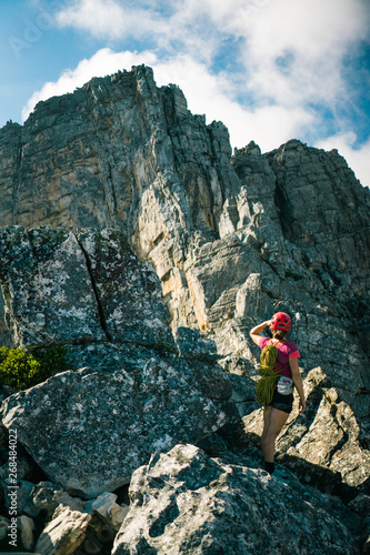 A female climber looking at a high mountain peak.