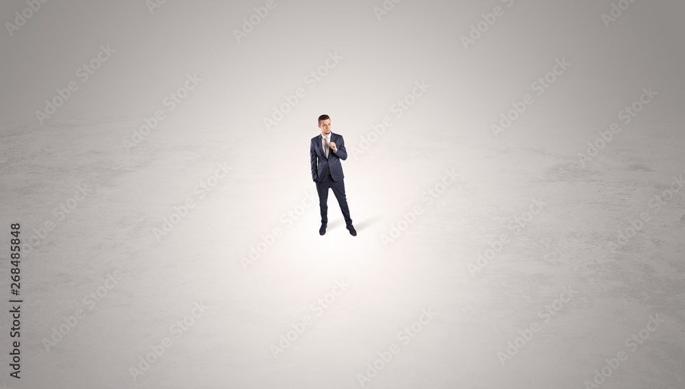 Young businessman standing alone in the middle of an empty space
Young businessman standing alone in the middle of an empty space