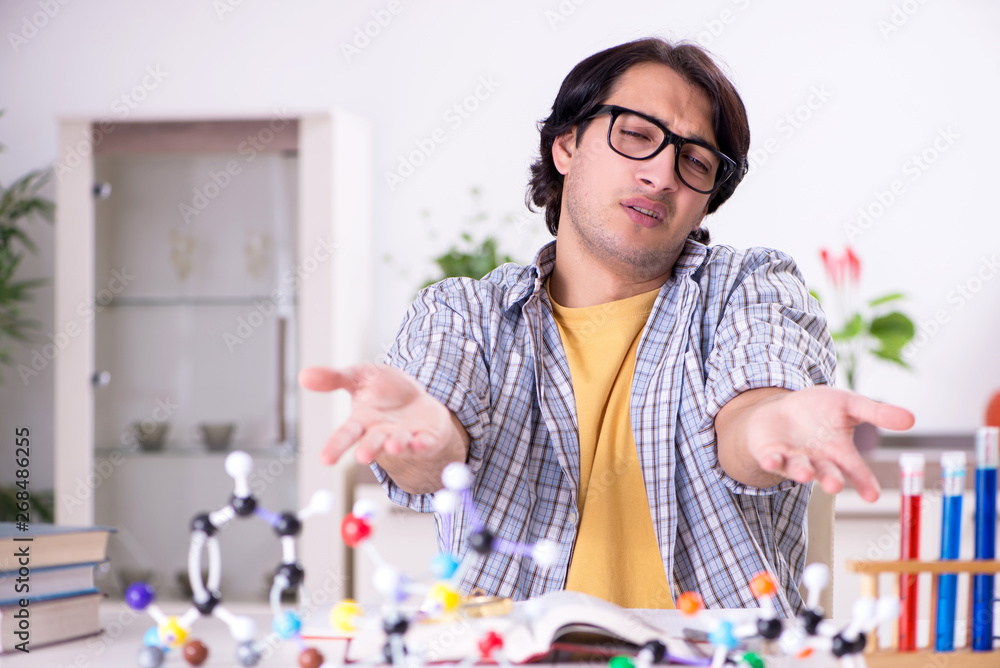 Young student physicist preparing for exam at home Young student physicist preparing for exam at home