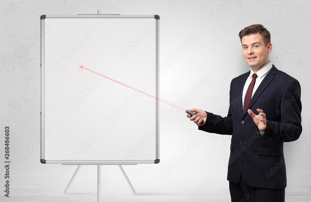 Young businessman with laser pointer and copyspace white blackboard Young businessman with laser pointer and copyspace white blackboard