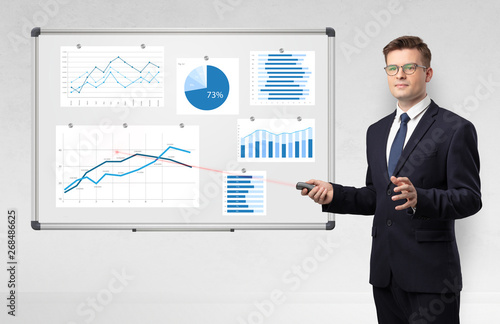 Handsome businessman presenting report on white board with laser pointer 