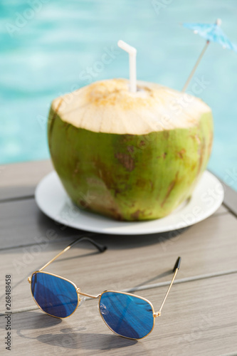 Fresh coconut drink and sunglasses on the table