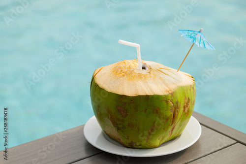 Coconut drink on the table beside the swimming pool