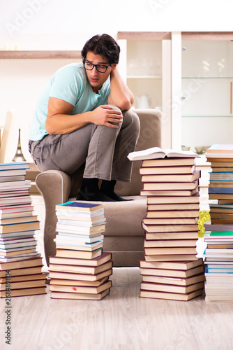 Male student with many books at home 