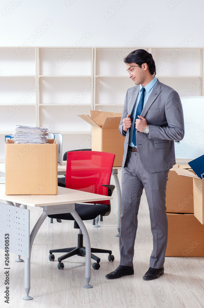Young man employee with boxes in the office Young man employee with boxes in the office
