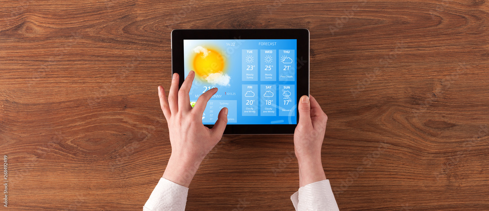 Man hand checking weekly weather forecast on tablet
 - obrazy, fototapety, plakaty 