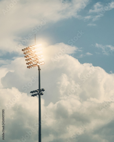 Stadium floodlights against cloudy sky