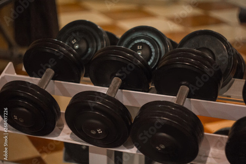 Fototapeta Naklejka Na Ścianę i Meble -  hand metal dumbbells lie together in a row on the rack in the gym close-up. training tools