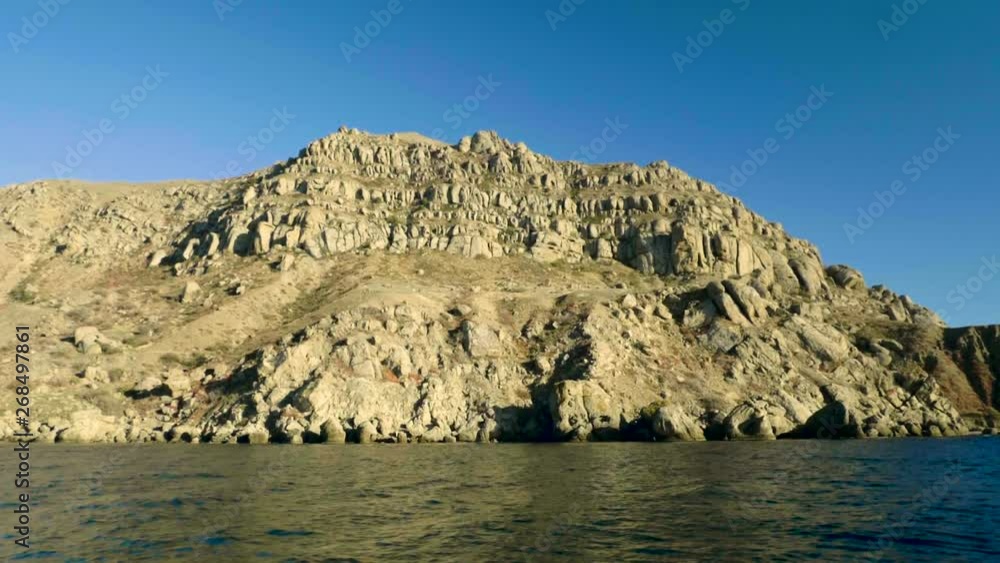 Rocky shore. View of mountain from the sea surface. Slow motion. HD Rocky shore. View of mountain from the sea surface. Slow motion. HD