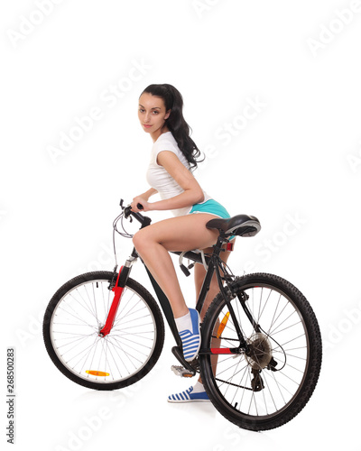 Young seductive woman in sport wear posing on the bicycle