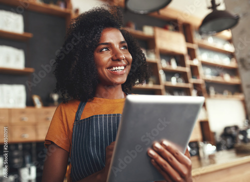 An african female owner of cafe holding digital tablet