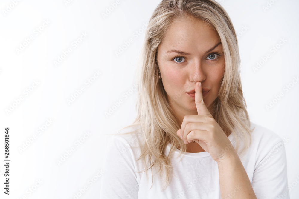 Shhh better not talk. Portrait of serious-looking sensual attractive blond woman holding index finger on lips saying shush keep secret safe, gossiping posing flirty over white background