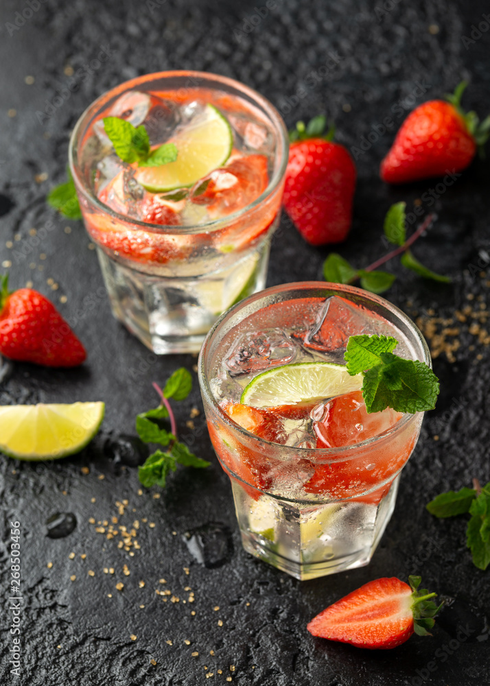 Strawberry Mojito cocktail with Rum, lime and mint in glass. Summer cold drink with ice Strawberry Mojito cocktail with Rum, lime and mint in glass. Summer cold drink with ice