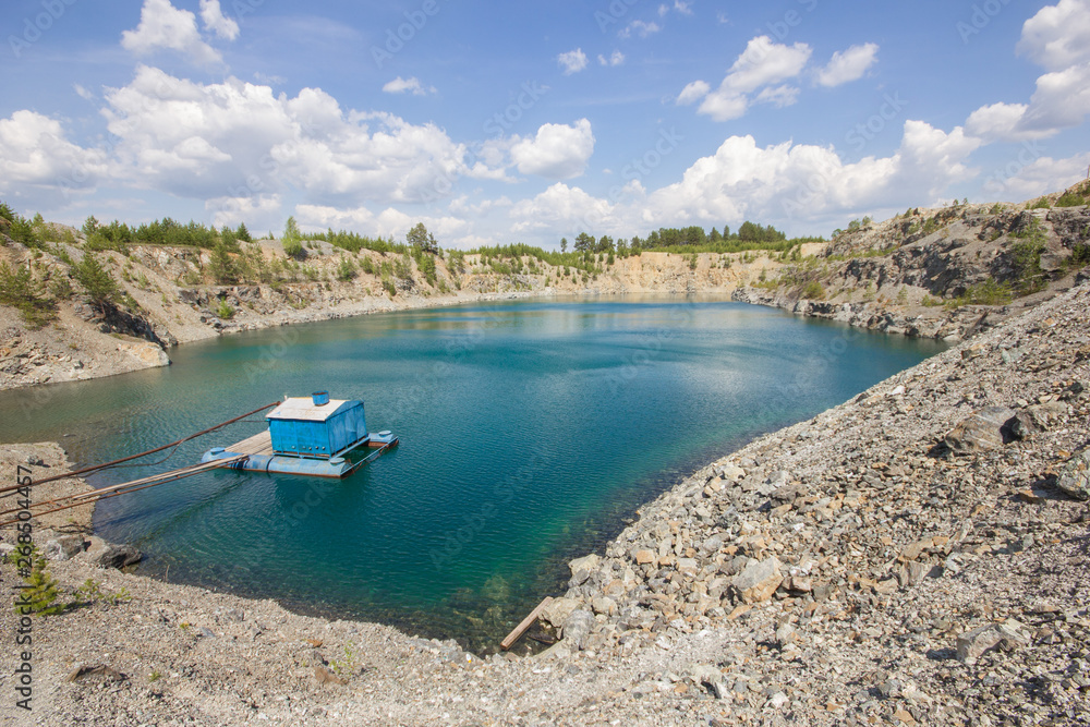 Open pit mining gold quarry with blue water Open pit mining gold quarry with blue water