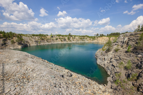 Open pit mining gold quarry with blue water