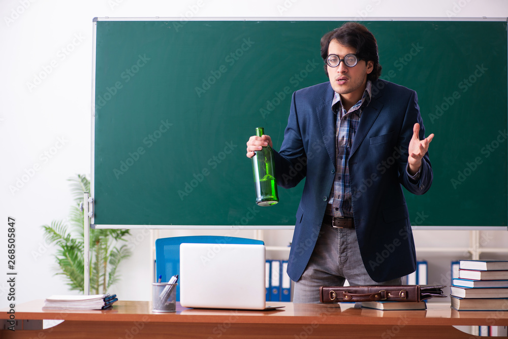 Male teacher drinking in the classroom Male teacher drinking in the classroom