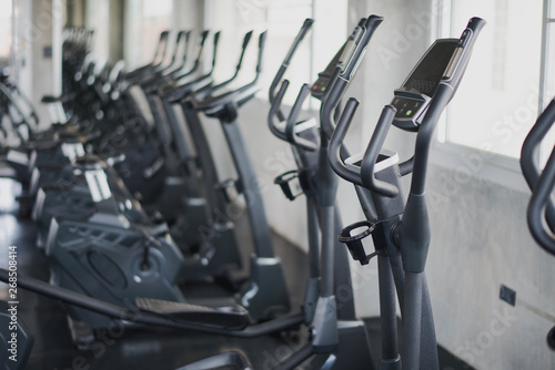 Cycling machine set in fitness club, weights taring equipment, selective focus, equipment in gym.