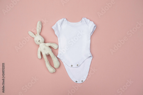 Valokuva Blank white baby bodysuit/grow with cream rabbit soft toy on a pastel pink backg