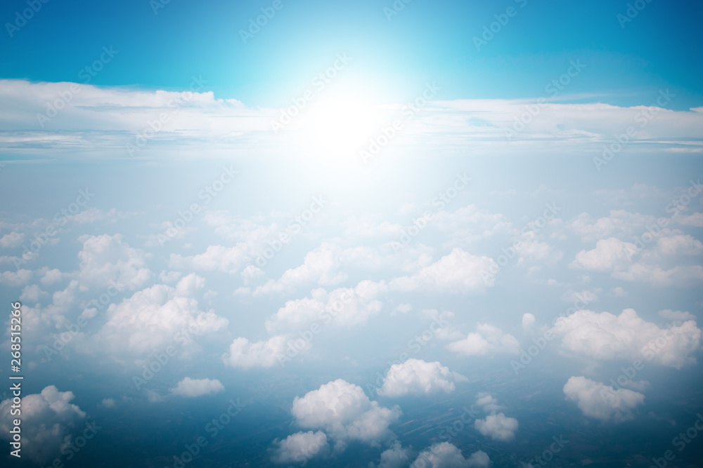 View of the sky clouds above the clouds from airplane window with sun light retro color filter