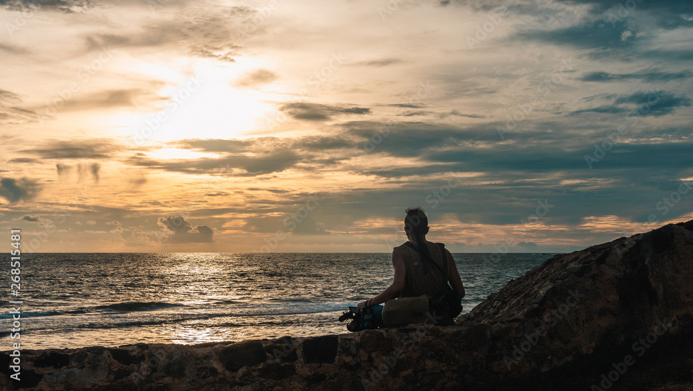 man sitting on a castle wall against sunset in Galle, Sri Lanka