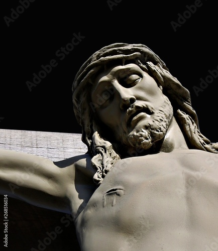 Foto Close-up looking up at face and wounds of Jesus Christ on outdoor crucifix isola
