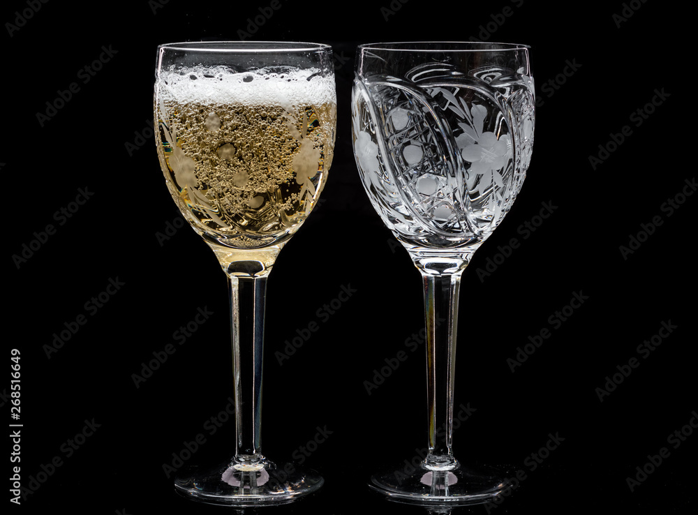 Two crystal wine glasses with a drink, falling ice and splashes Two crystal wine glasses with a drink, falling ice and splashes