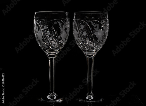 Two crystal wine glasses with a drink, falling ice and splashes
